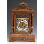 An early 20thC oak cased mantel clock with Junghans two train movement chiming on five bars, Roman