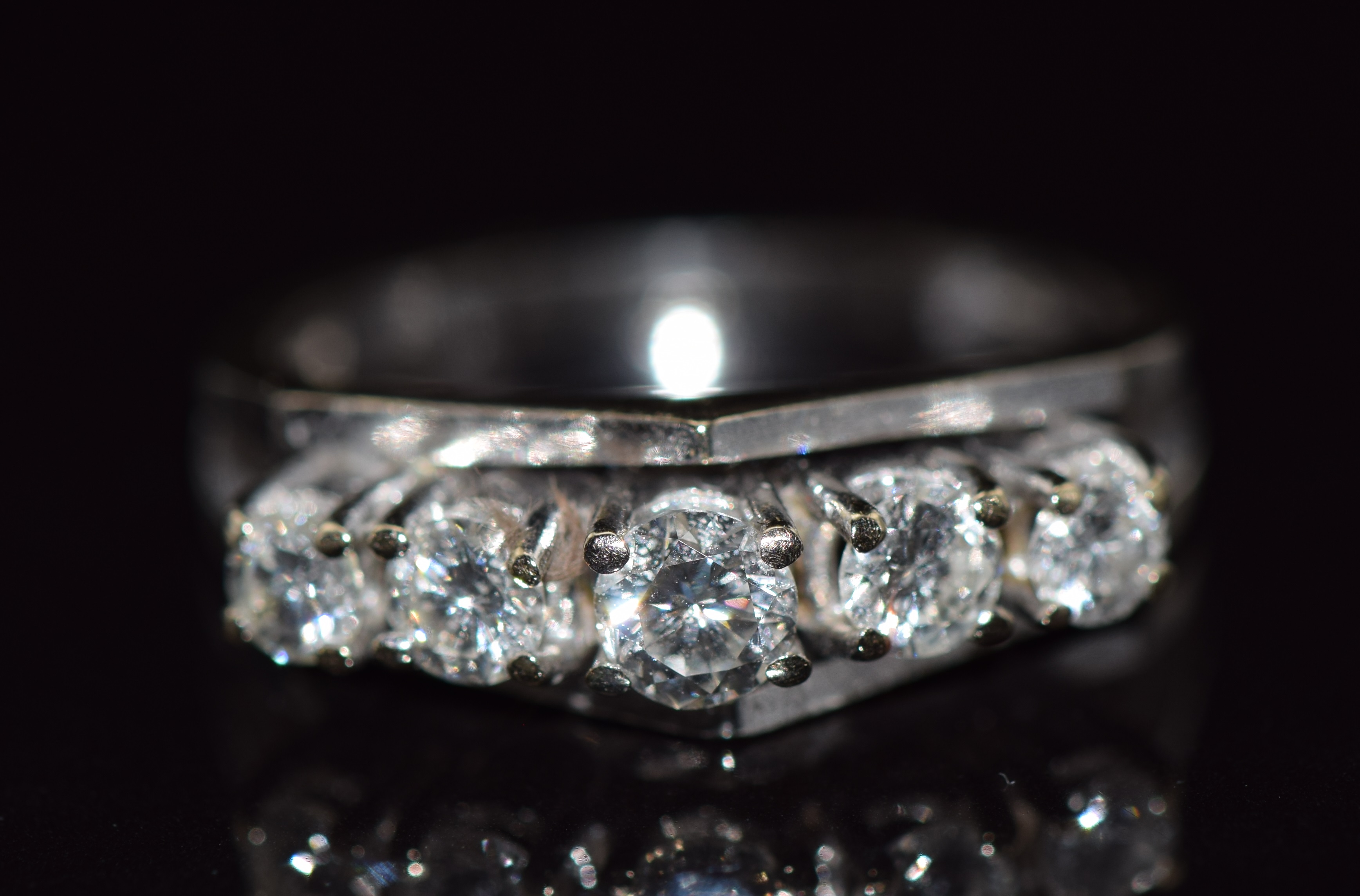 An 18ct gold ring set with five graduated diamonds in a bespoke setting, total diamond weight