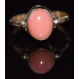 A 9ct gold ring set with an oval coral cabochon, 1.9g, size J/K