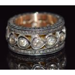 A large pierced gold ring set with diamonds in foiled settings with further diamonds to the edges