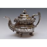 William IV hallmarked silver teapot with ornate embossed floral decoration and reeded lower body,