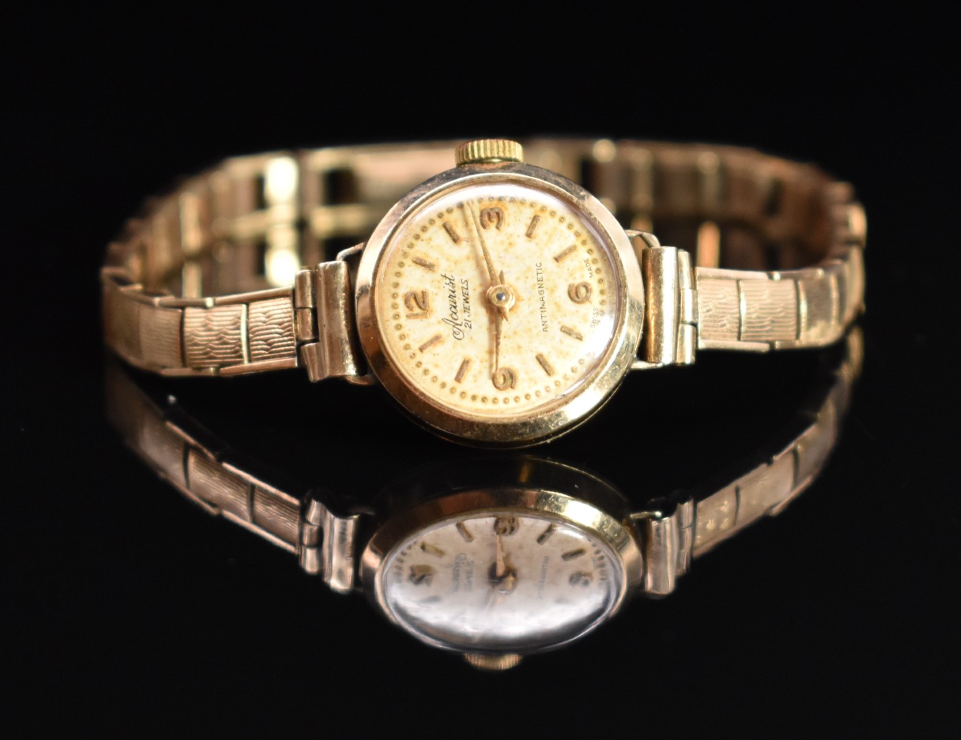 Accurist 9ct gold ladies wristwatch with gold hands, hour markers and Arabic numerals, champagne