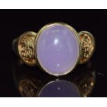 A 14ct gold ring set with a lavender jade cabochon with Chinese character decoration to the