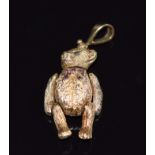 A 9ct gold articulated teddy bear pendant set with sapphires and rubies, 17.7g