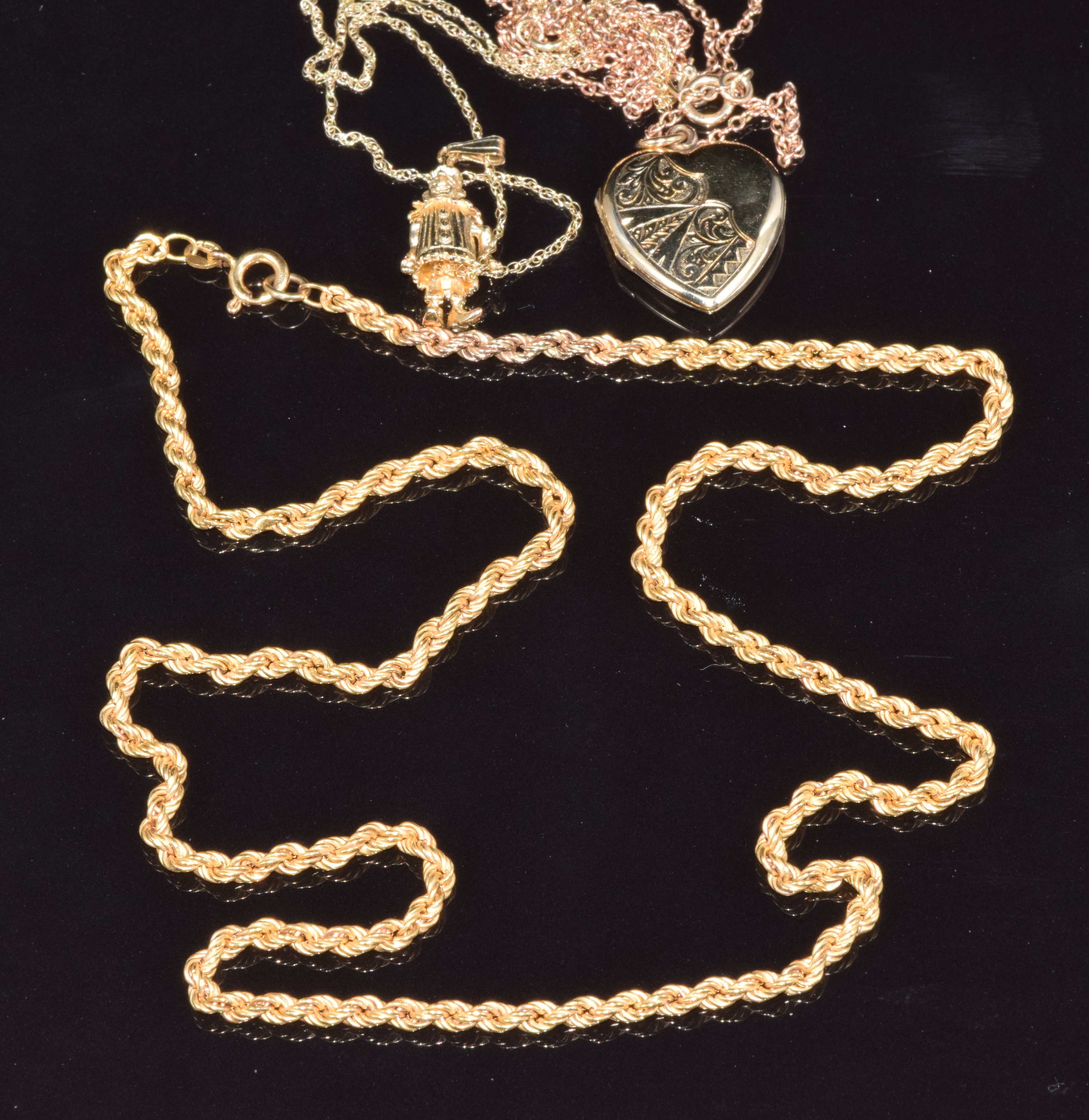 Three 9ct gold necklaces/chains, a 9ct gold clown pendant and a 9ct gold heart padlock, 13g