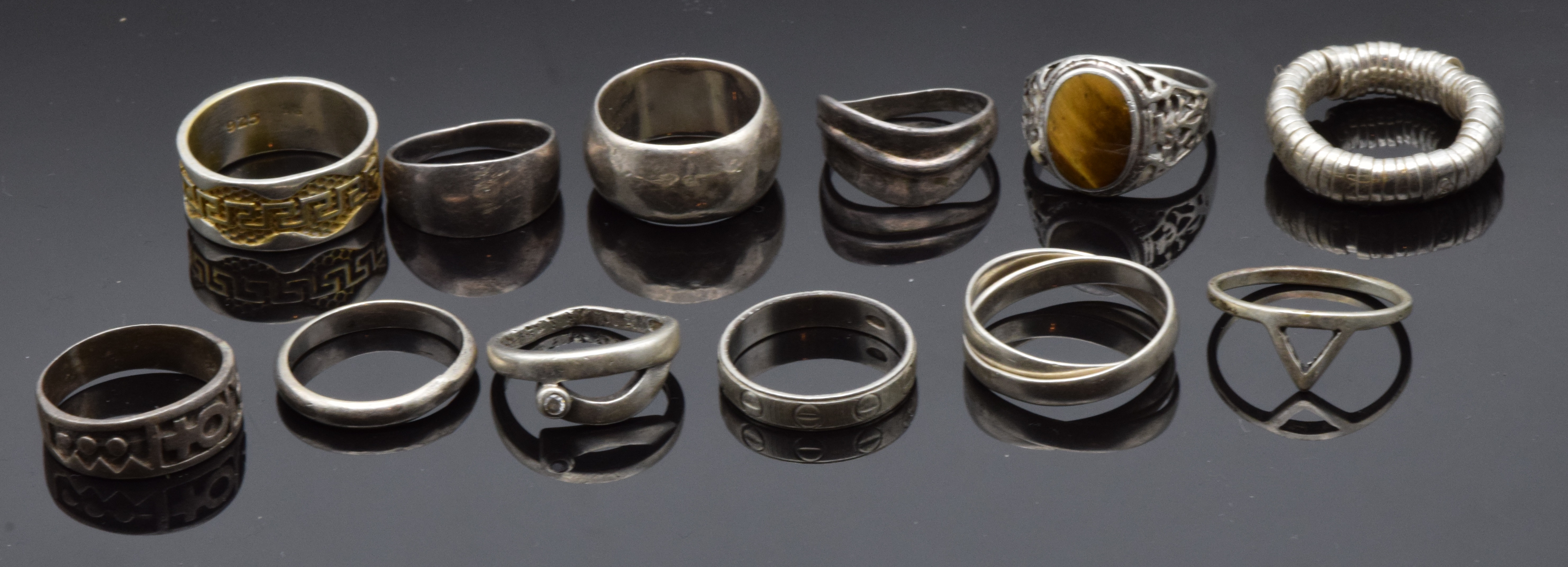 Twelve silver rings including one set with tiger's eye, 43g