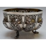 Indian or Burmese white metal bowl with lobed and embossed decoration, raised on three fish feet,