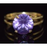 An 18ct gold ring set with a round cut purple sapphire, 4g, size M