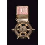 A 9ct gold charm in the form of a compass and a 9ct gold charm set with a 10 shilling note, 4.8g