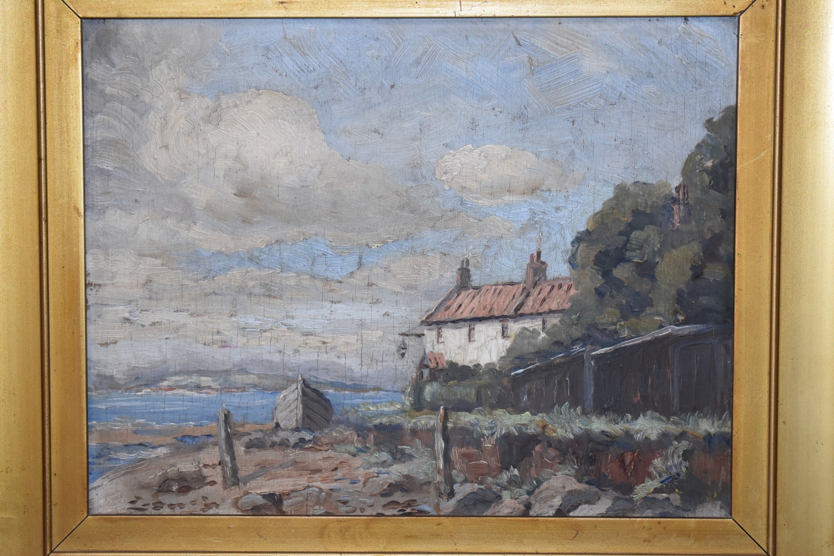 Early 20thC impressionist oil on board coastal landscape with beached boat by a cottage with