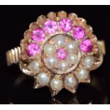 A yellow metal ring set with round cut rubies and seed pearls in a cluster, size K, 4.3g