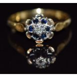 An 18ct gold ring set with a diamond and sapphires, 3.1g, size P