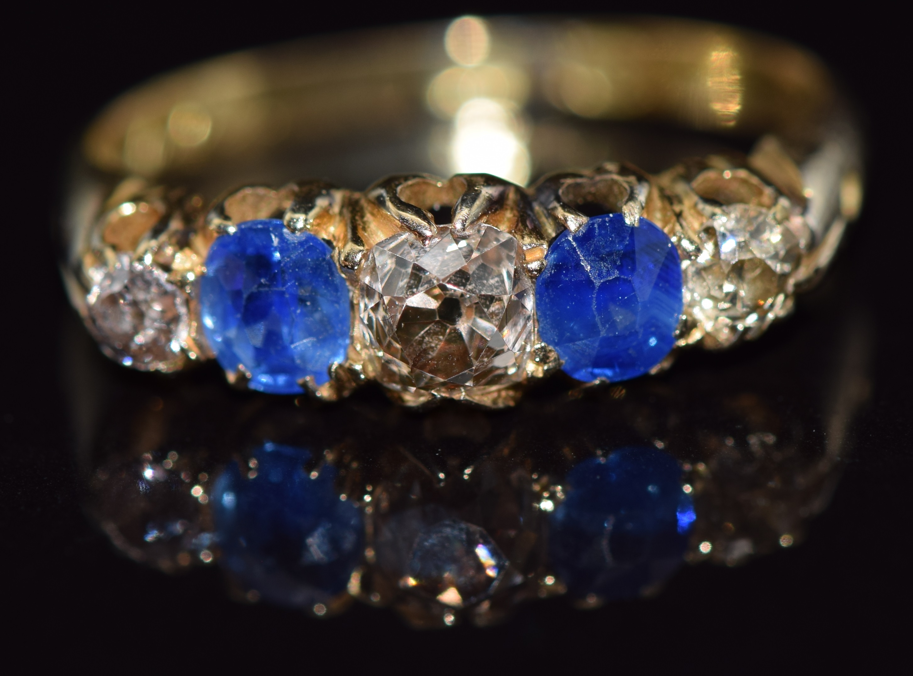 Edwardian 18ct gold ring set with diamonds and sapphires, the central diamond approximately 0.