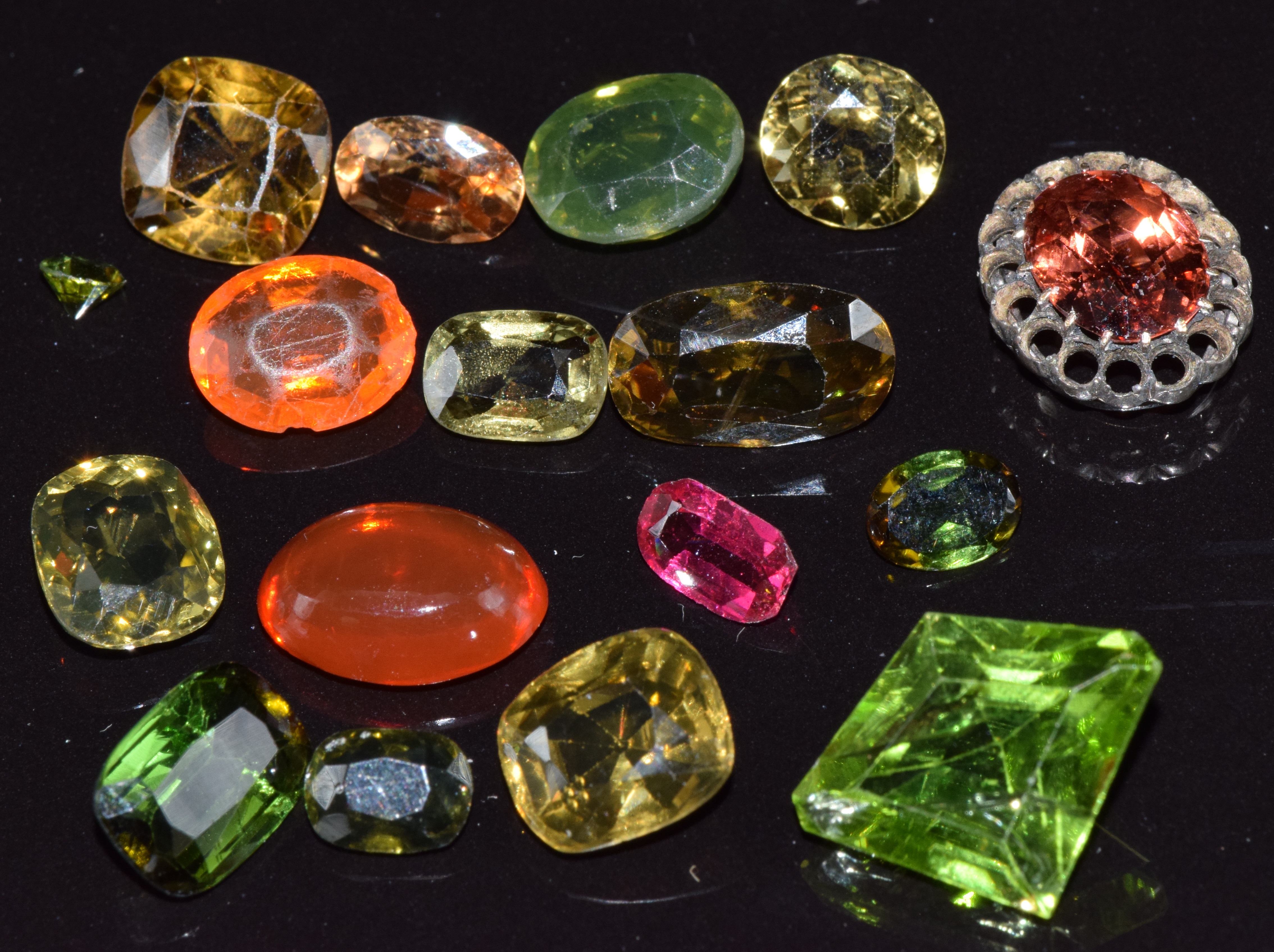 A collection of loose peridot, tourmaline, diopside, etc