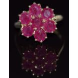 A 9ct gold ring set with round cut rubies in a cluster, 4.7g, size O