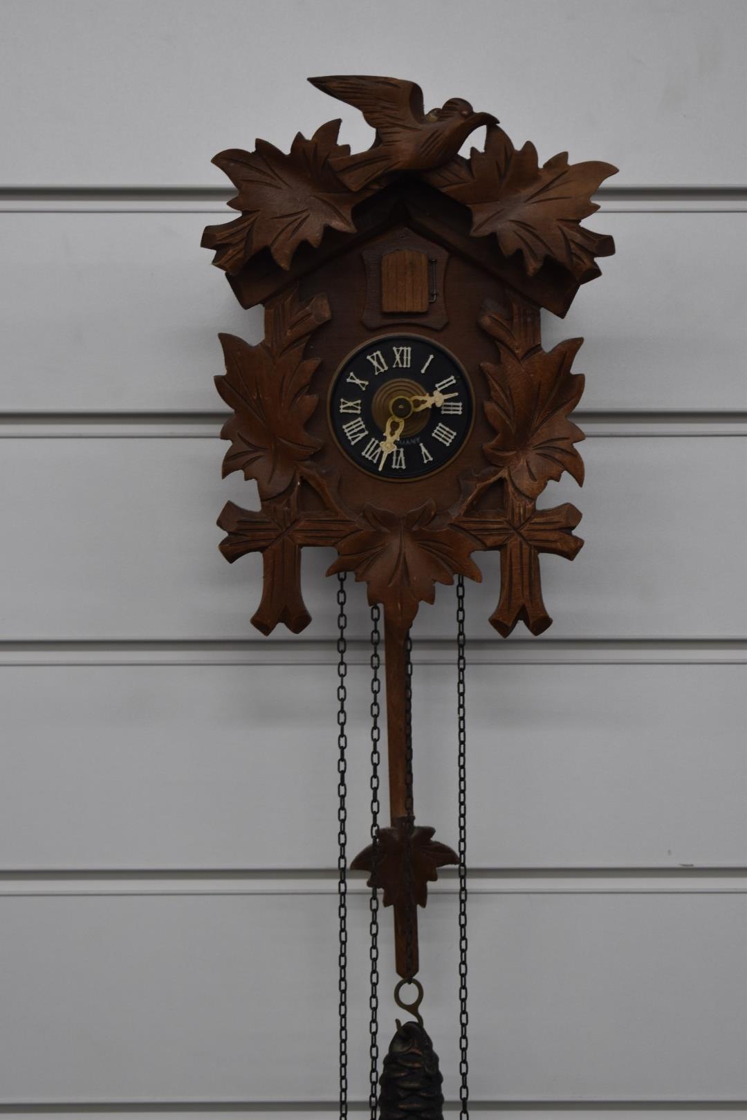 Mid to late 20thC carved wood German cuckoo clock in the Black Forest style, complete with two '