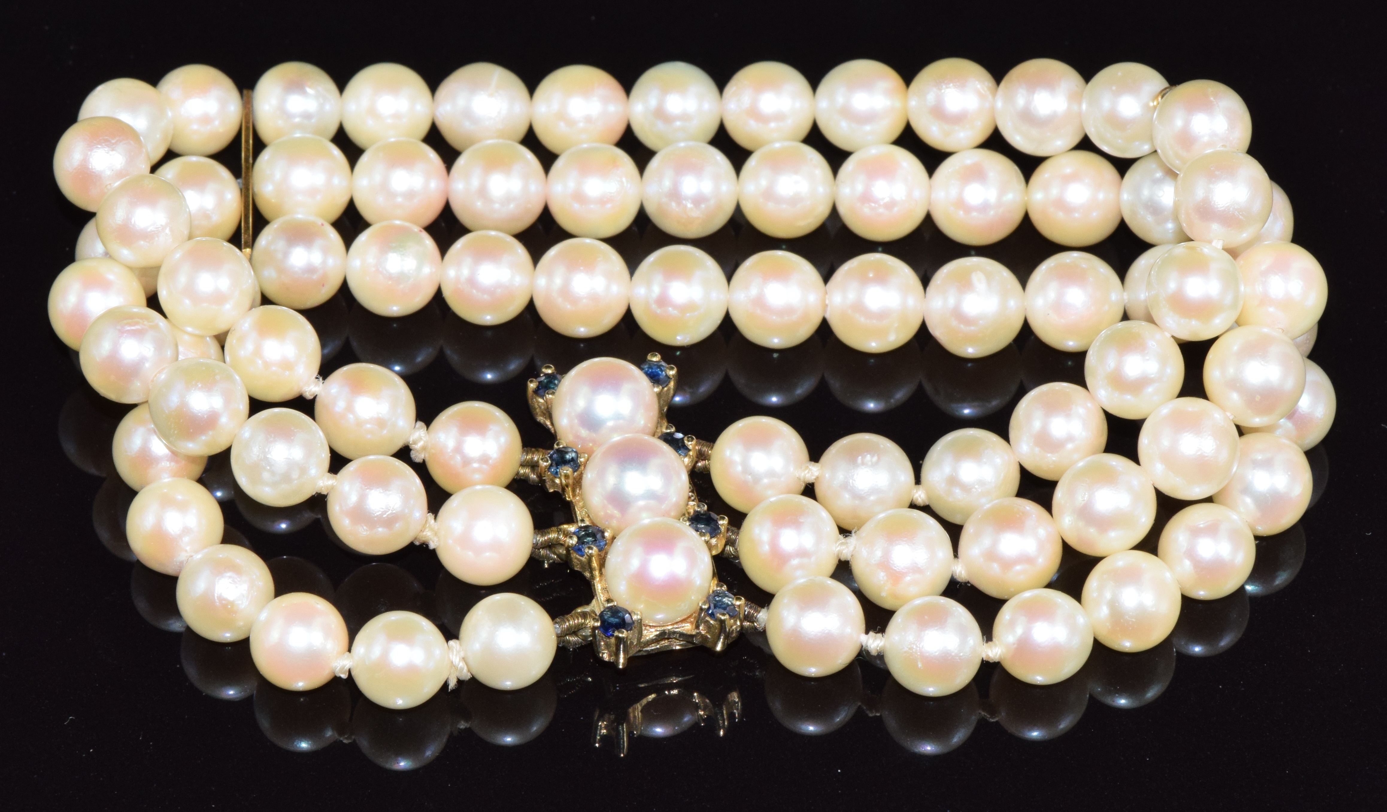 A three strand cultured pearl bracelet, the 9ct gold clasp set with sapphires and pearls