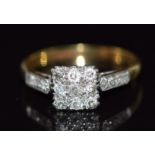 An 18ct gold ring set with nine diamonds in a square platinum setting with further diamonds to the