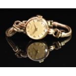 Tissot 9ct gold ladies wristwatch with gold hands and Arabic numerals, champagne dial and signed
