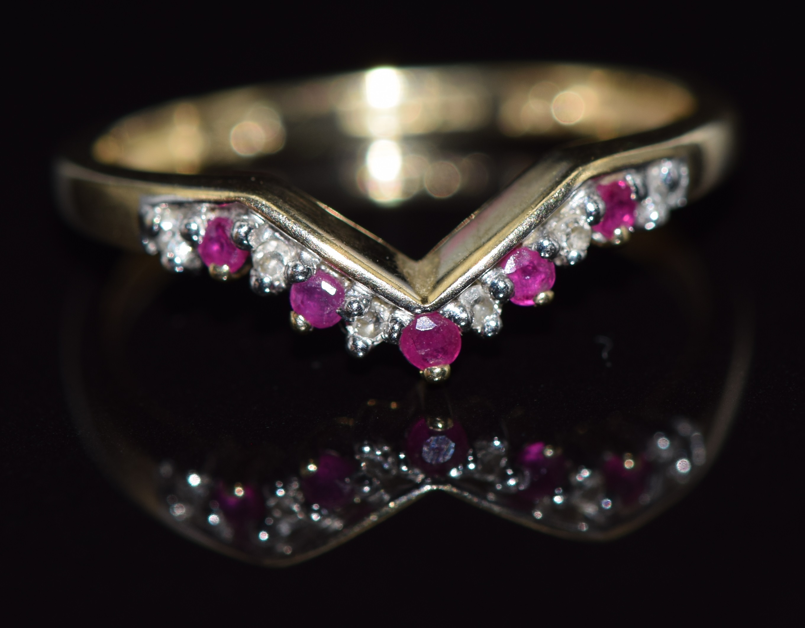 A 9ct gold ring set with rubies and diamonds in a V setting, 1.5g, size N