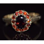 A 9ct gold ring set with garnets in an oval cluster, 2.5g, size O