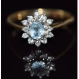 A 9ct gold ring set with an oval cut aquamarine surrounded by diamonds, 2.2g, size O