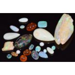 A carved opal in the form of a man, two pearl cut loose opals, three loose fire opal cabochons,