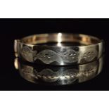 A 9ct gold bangle with cut out foliate decoration, 10.5g
