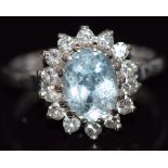 An 18ct white gold ring set with an oval cut aquamarine surrounded by diamonds, 4.6g, size K