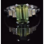 An 18ct white gold ring set with an emerald cut tourmaline and two baguette cut diamonds to each