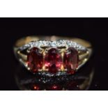 A 9ct gold ring set with oval cut garnets, 1.4g, size N