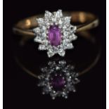 A 9ct gold ring set with an oval cut ruby and diamonds, 2.3g, size O