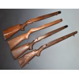 Four bolt-action wooden rifle stocks, some with chequered semi-pistol grips, sling mounts and inlay.