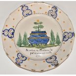 An 18th/19th century French Delft plate decorated with a jardinière, diameter 23cm
