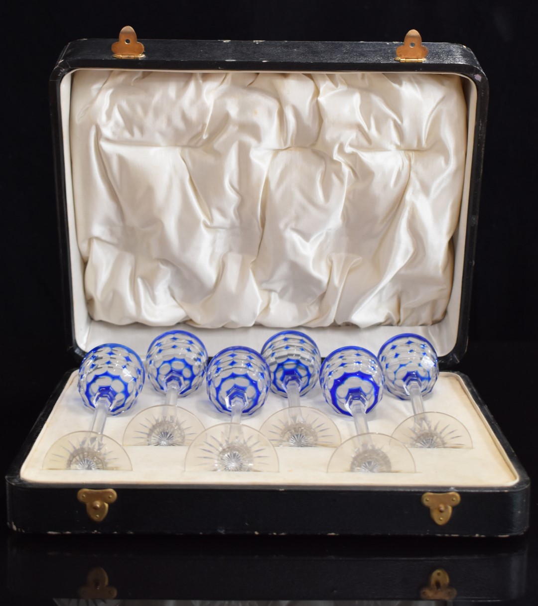 A set of six blue overlay cut glass liqueur glasses with octagonal stems and star cut bases, 14.