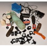 A collection of gun and shooting accessories including scope mounts, cleaning kit, butt plates,