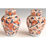 A pair of 19thC Oriental lidded jars of bulbous form, with Imari decoration, internal cover and lid,