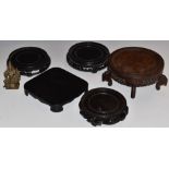 Four Chinese wooden stands and a bronze deity, largest stand diameter 17cm