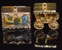 A 9ct gold charm is the form of a cart and a 9ct gold charm with a 5 shilling note inside, 9.1g