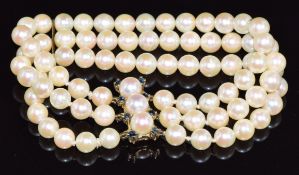 A three strand cultured pearl bracelet, the 9ct gold clasp set with sapphires and pearls and a 9ct
