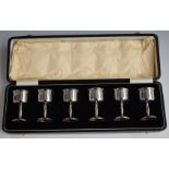 George V cased set of six hallmarked silver shot measures or tots, Birmingham 1928, maker Adie