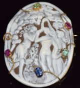 A moulded plastic cameo depicting the Three Graces set with emeralds, rubies and a sapphire, 5.8 x