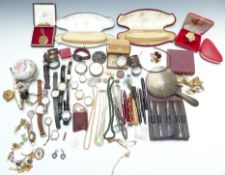 A collection of costume jewellery including silver napkin rings, silver handled manicure set,