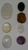A collection of carved cabochons comprising three moonstone, tiger's eye, onyx and amethyst