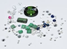 A collection of loose diamonds, tourmalines, emeralds and sapphires