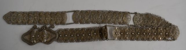A silver filigree belt marked 850