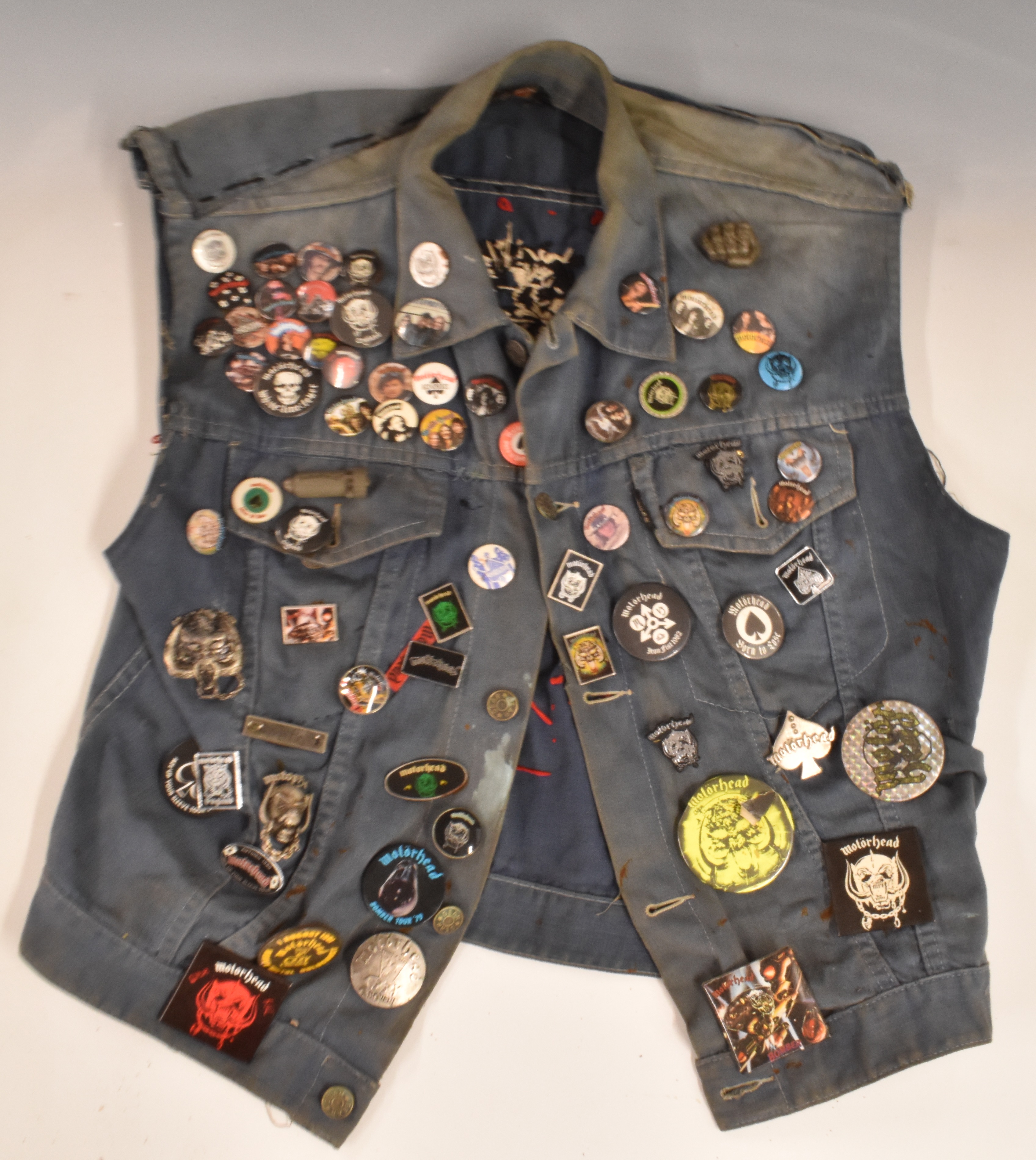A collection of c1980's Motorhead and other heavy metal related badges, on a denim waistcoat with