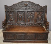 Victorian carved oak settle with figural decoration and lion mask finials to arms, W154 x H136