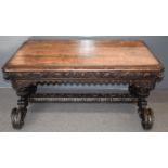 Victorian carved oak library table with moulded frieze, raised on twin ornate supports and two