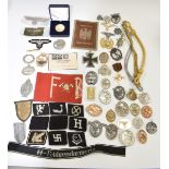 Approximately fifty replica German Nazi insignia and badges including metal and cloth examples